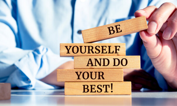 Close up on businessman holding a wooden block with "Be yourself and do your best!" message