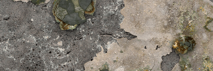 Peeling paint on the wall. Panorama of a concrete wall with old cracked flaking paint. Weathered rough painted surface with patterns of cracks and peeling. Wide panoramic grunge texture for background