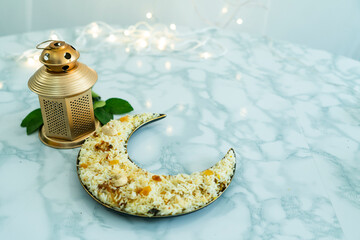 Golden lantern lamp and rice, Ramadan and Eid al fitr concept crescent moon Selective focus