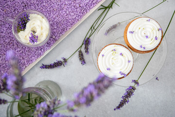 Two mousse cakes decorated with lavender flowers with cappuccino with cream