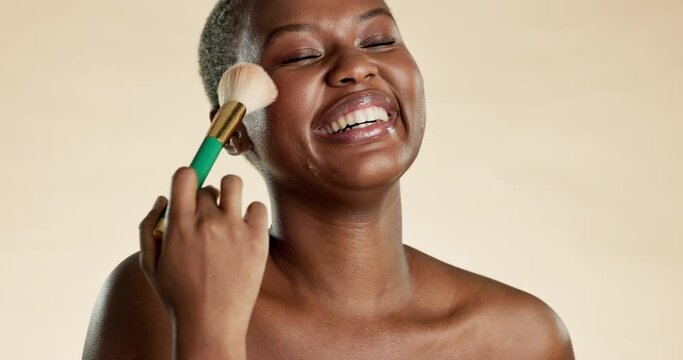 Beauty, makeup and black woman with a brush in a studio for a cosmetic, natural and face routine. Beautiful, happy and portrait of African model doing cosmetology facial treatment by brown background