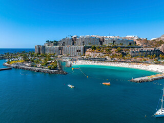 Obraz premium Beautiful aerial landscape with Anfi beach and resort, Gran Canaria, Spain. Luxury hotels, turquoise water, sandy beaches in Spain. Luxury beach vacation concept. Heart shaped island.