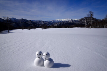 雪原にキャラクターの仲良し雪ダルマ