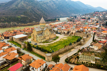 Picturesque aerial view of old Georgian city of Mtskheta surrounded by Caucasus mountains...