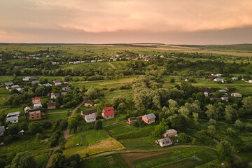 Fototapeta na wymiar Aerial view of residential houses in suburban rural area at sunset