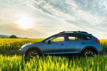 Subaru Crosstrek car at sunrise on farmland field. Traveling by auto, adventure in wildlife,...