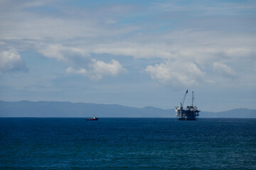 California coast with an offshore oil rig and cranes