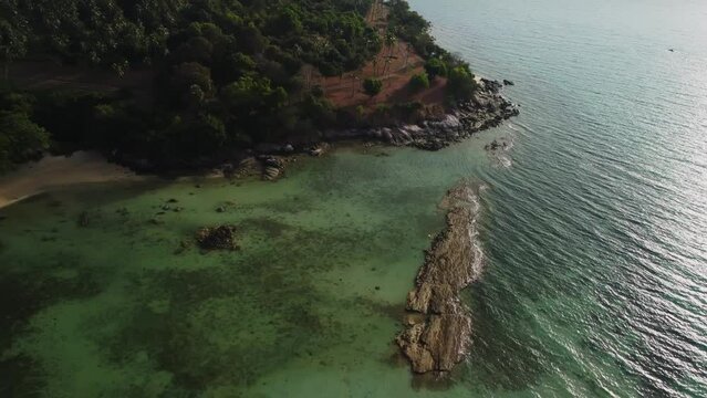 Islands with mountains covered by trees and palms are washed by sea filmed by drone. Aerial footage of rocky coastline and ocean. Travelling and exploring nature and landscapes of Thailand concept
