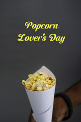 A day for Popcorn Lover's, March 9th A white paper cone with popcorn Selective focus