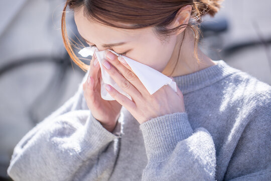 テッシュで鼻を抑える女性　Hay Fever