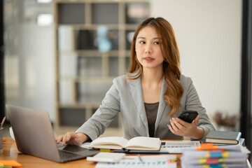 Asian businesswoman holding notebook about business, spending money