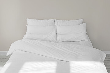 Fototapeta na wymiar White soft pillows on cozy bed in room