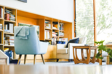 Modern bright living room featuring pastel blue chair well-lit on bright spring day