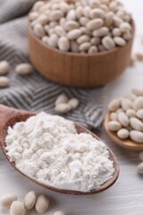 Kidney bean flour and seeds on white wooden table, closeup