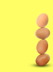 Stacked fresh chicken eggs against light yellow background. Space for text