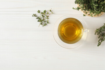 Aromatic herbal tea with thyme on white wooden table, flat lay. Space for text