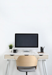 Cozy workspace with computer, houseplant and stationery on wooden desk at home