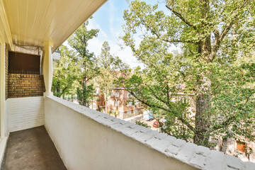 a balcony with trees and houses in the background, taken from an apartment window looking out to...