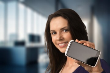 Fototapeta premium Smiling young woman posing with phone
