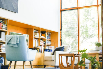 Modern bright living room featuring pastel blue chair well-lit on bright spring day