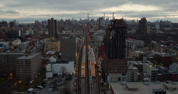 Drone shot over the Harlem 125th Street station, towards the Manhattan skyline, cloudy evening in NY, USA