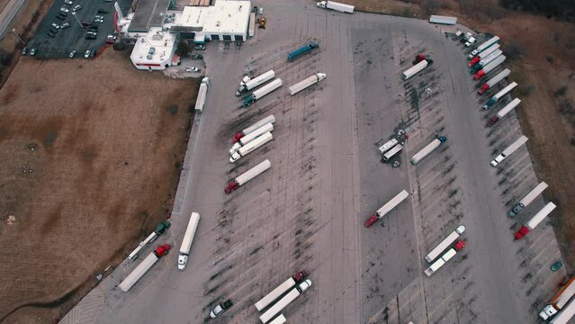 Dry van trailer semi truck driver exiting truck stop parking lot. Aerial 4k Illinois-Wisconsin border, USA