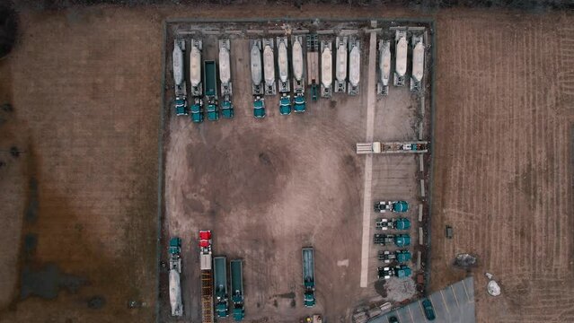 rising top down tankers semi trucks parked in a pleasing pattern. Green cabs. Top down aerial view USA 4k