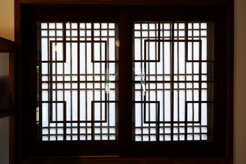 Wooden window of asian traditional architecture. Dark and  window of oriental with traditional pattern. Asian traditional interior design.
