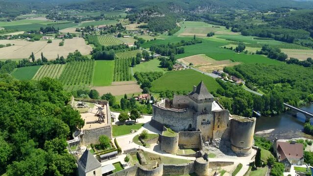 4K aerial footage of the Chateau de Castelnaud-la-Chapelle, which is a medieval fortress in the commune of Castelnaud-la-Chapelle, overlooking the river Dordogne in P&eacute;rigord, Southern France.
