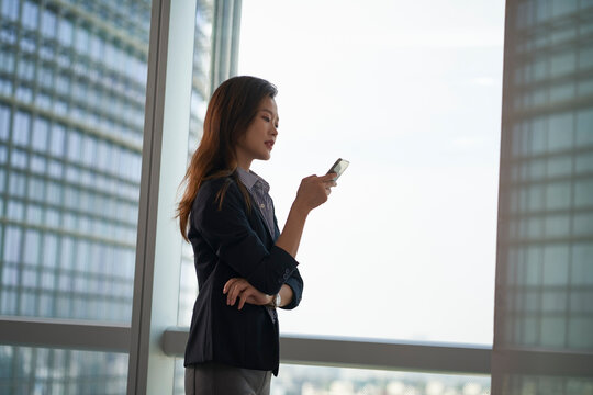 young asian businesswomen looking at mobile phone in modern office
