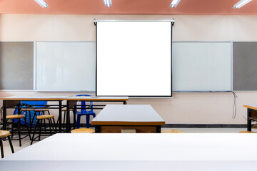 Projector screen canvas in modern conference room with big windows. Side view.Empty classroom or presentation room interior with desks, foreground table