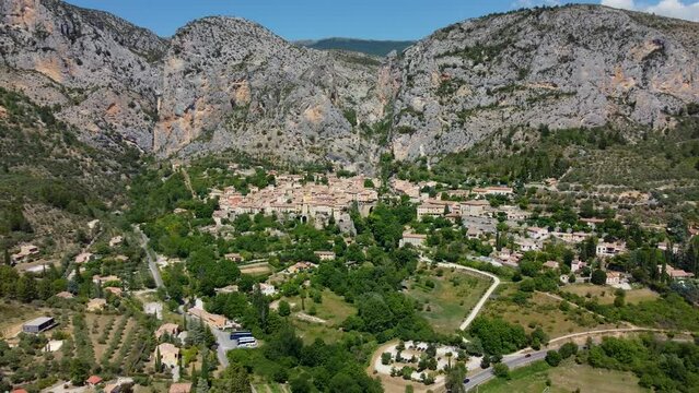 Smooth 4K footage of Moustiers-Sainte-Marie or Moustiers, a village perched on terraces on the side of a limestone cliff in the Alpes-de-Haute-Provence department in the Provence-Alpes-Côte d'Azur.