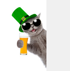 Fototapeta St. Patricks Day concept. Happy cat holds glass of beer looks from behind empty white banner. isolated on white background obraz