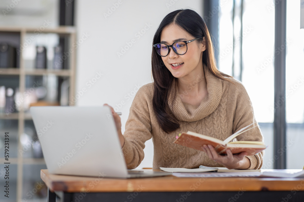 Wall mural Asian Business woman using calculator and laptop for doing math finance on an office desk, tax, report, accounting, statistics, and analytical research concept
