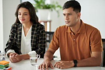 Married young couple visiting bank manager to discussing mortgage