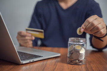 Fototapeta premium Man putting coin in jar. investment and money saving, banking and finance, online shopping on the internet, accounting and tax Business concept.