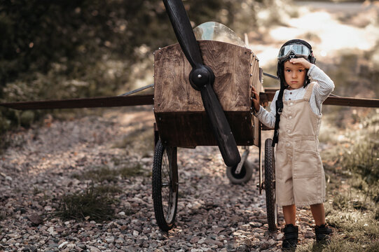 A young boy aviator on a homemade airplane in a natural landscape Authentic mood of the picture. Vintage.
