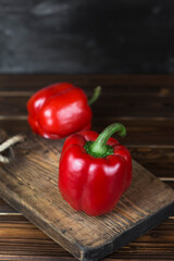 red fresh ripe paprika on wooden board