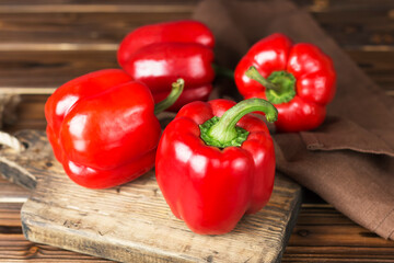 red fresh ripe paprika on wooden board