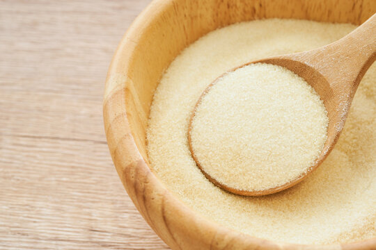 gelatin powder in wood bowl and spoon on wooden table background. pile of gelatin powder in wood spoon. gelatin powder                                         
