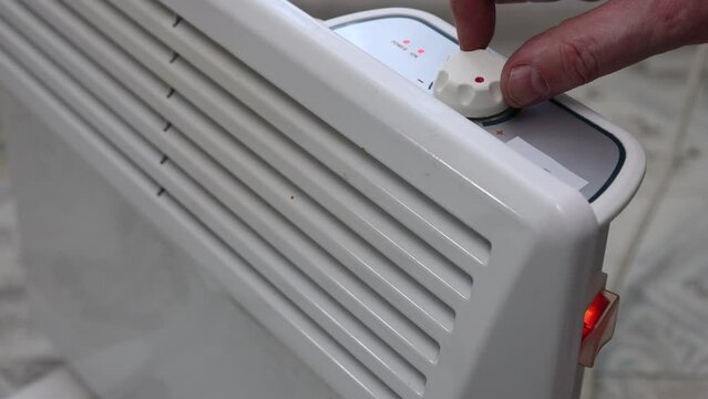 Switch on electric convector heater by turning thermostat dial.