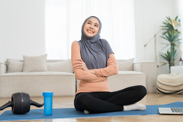 Asian young muslim woman wear hijab doing yoga on yoga mat at home. Young muslim female workout on mat at home