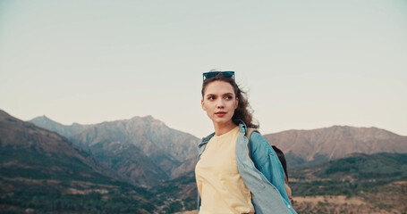 Portrait of beautiful girl enjoying fresh air at the mountains. Beautiful natural woman looking at copy space, freedom concept