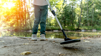 a boy with a metal detector is looking for treasure in the forest