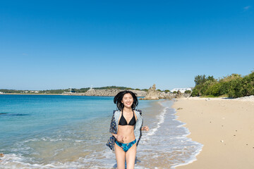 Fototapeta na wymiar 沖縄の海で恋人と走る女性