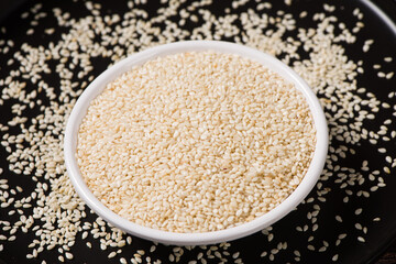 white sesame seeds in plate on wooden table