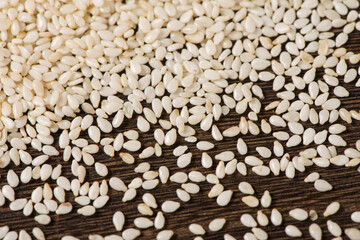 closeup of white sesame seeds on wooden table