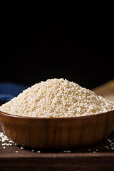 white sesame seeds in wooden bowl on table.