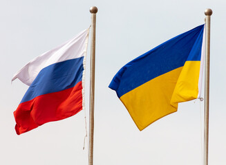 Flags of Russia and Ukraine against the sky.