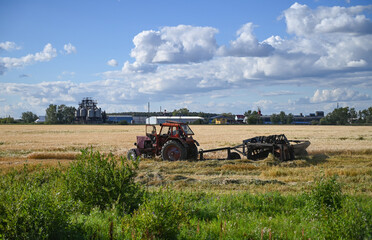 Combine harvester harvests ripe wheat. Ripe ears of gold field on the sunset cloudy orange sky background. . Concept of a rich harvest. Agriculture image.